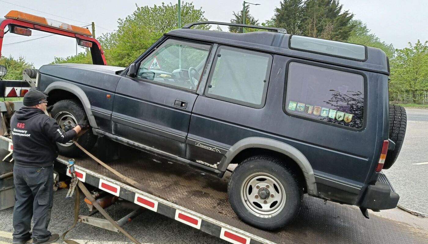 Land Rover Discovery being lifted onto the back of a breakdown lorry